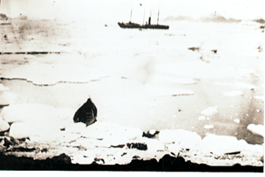 Image: Vessel in distance, small boat on shore